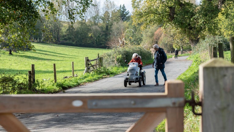 A woman in a tramper and a man walk the riverside loop at Saltram in Devon